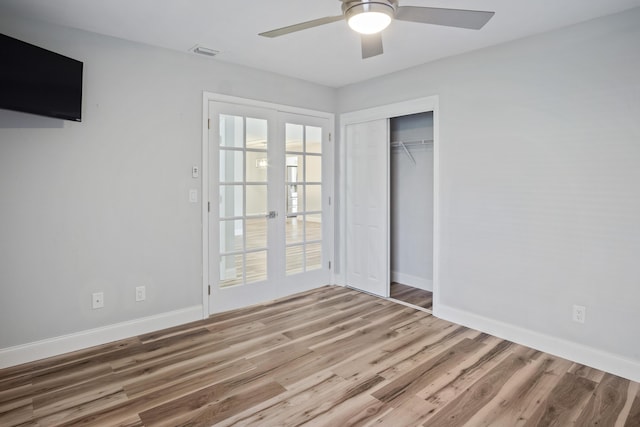 unfurnished bedroom featuring wood finished floors, visible vents, a closet, and baseboards