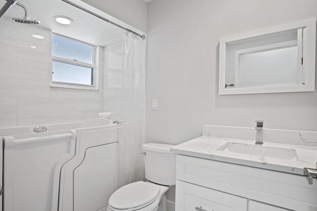 full bath featuring a shower with shower curtain, toilet, and vanity