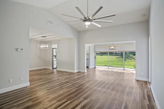 unfurnished living room with visible vents, lofted ceiling, wood finished floors, and ceiling fan with notable chandelier