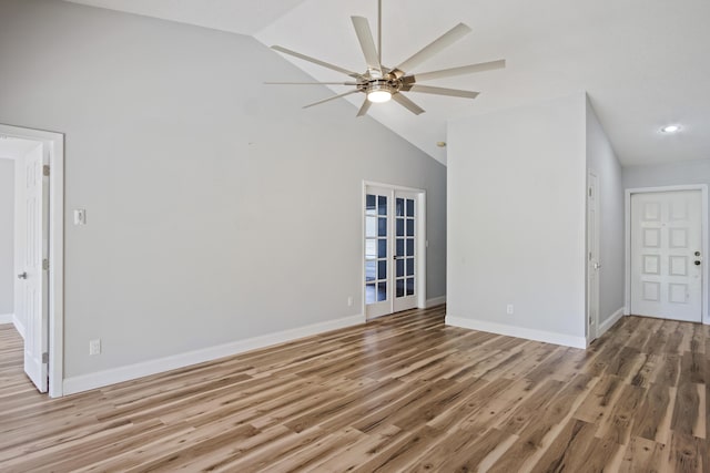 unfurnished room with high vaulted ceiling, light wood-style flooring, baseboards, and ceiling fan