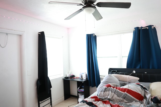 bedroom featuring multiple windows, light tile patterned floors, and ceiling fan