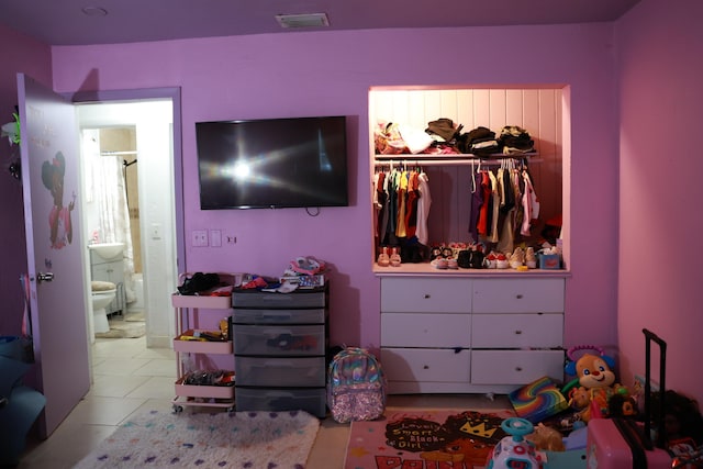 tiled bedroom with a closet and visible vents