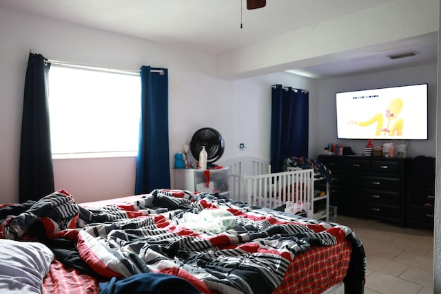 bedroom featuring light tile patterned flooring, visible vents, and a ceiling fan