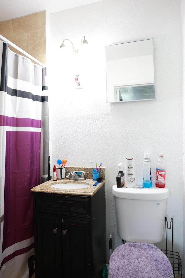 bathroom featuring a shower with curtain, toilet, and vanity