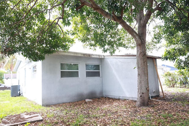 view of side of property featuring central AC and stucco siding