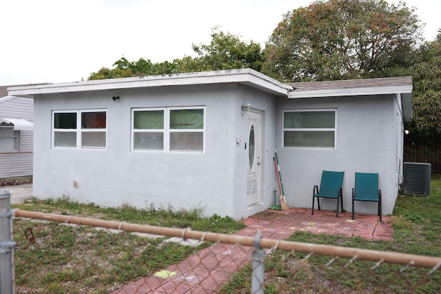 bungalow featuring central AC unit, stucco siding, a patio, and fence