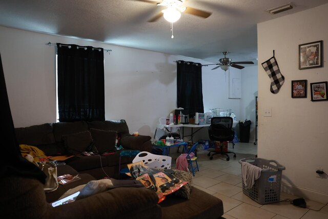 tiled living area featuring a textured ceiling, visible vents, and ceiling fan