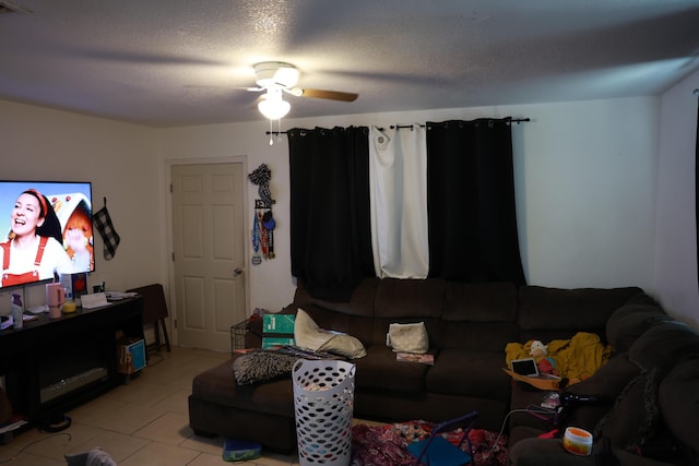 living room with light tile patterned flooring, a ceiling fan, and a textured ceiling