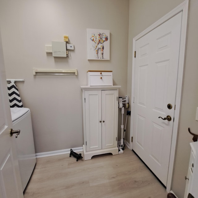 laundry room featuring washer / clothes dryer, light wood-type flooring, and baseboards