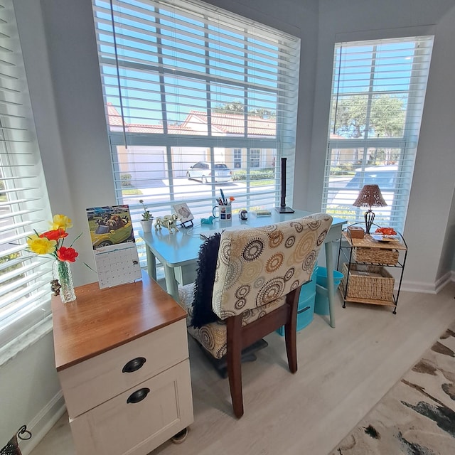 sitting room with baseboards and light wood-style flooring