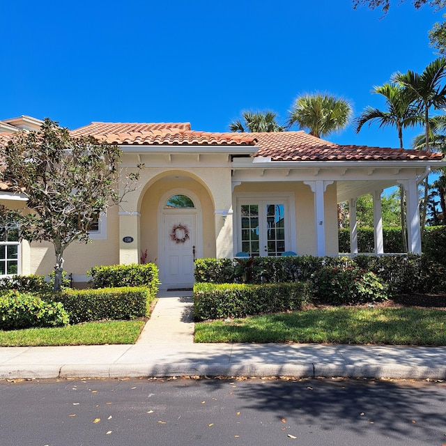 mediterranean / spanish home with stucco siding and a tile roof