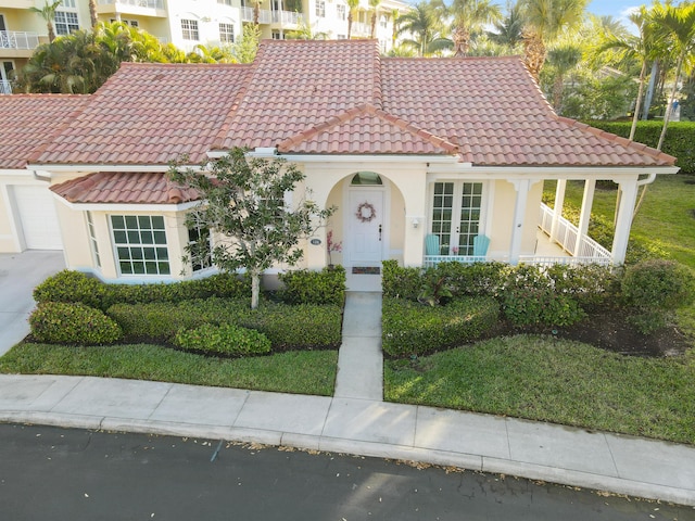 mediterranean / spanish-style house featuring stucco siding, a tiled roof, and french doors