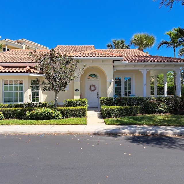 mediterranean / spanish-style house with stucco siding and a tiled roof