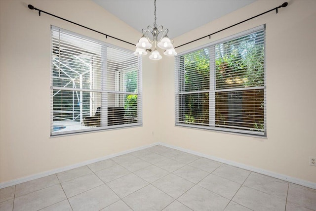 unfurnished room featuring tile patterned flooring, baseboards, an inviting chandelier, and vaulted ceiling