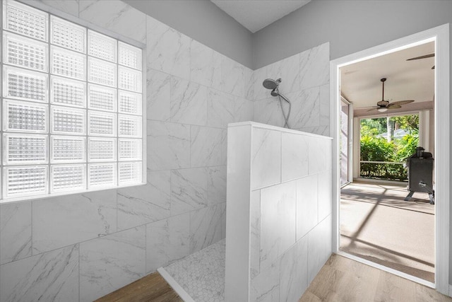 bathroom with wood finished floors, a walk in shower, and ceiling fan