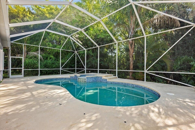 view of pool featuring glass enclosure, a patio, and a pool with connected hot tub