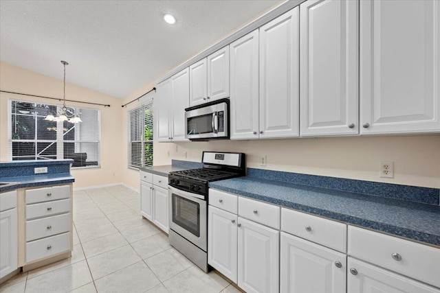 kitchen featuring dark countertops, light tile patterned floors, stainless steel appliances, and lofted ceiling