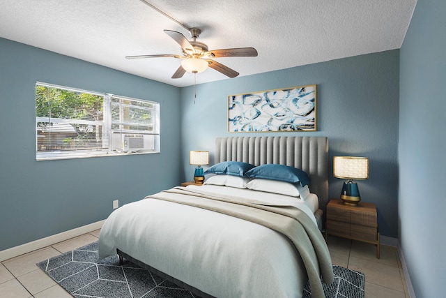 tiled bedroom featuring cooling unit, a textured ceiling, baseboards, and a ceiling fan