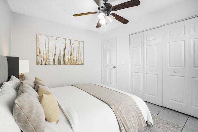 bedroom featuring light tile patterned floors, a ceiling fan, and a closet