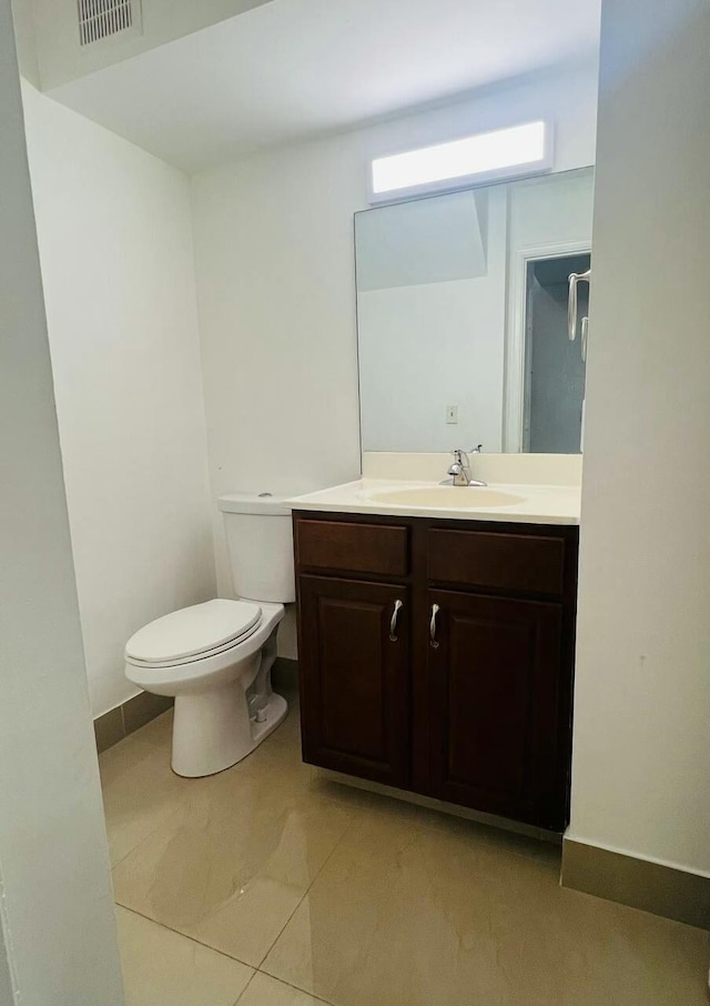 bathroom with visible vents, toilet, vanity, and baseboards