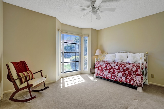 bedroom featuring carpet flooring, a textured ceiling, baseboards, and a ceiling fan