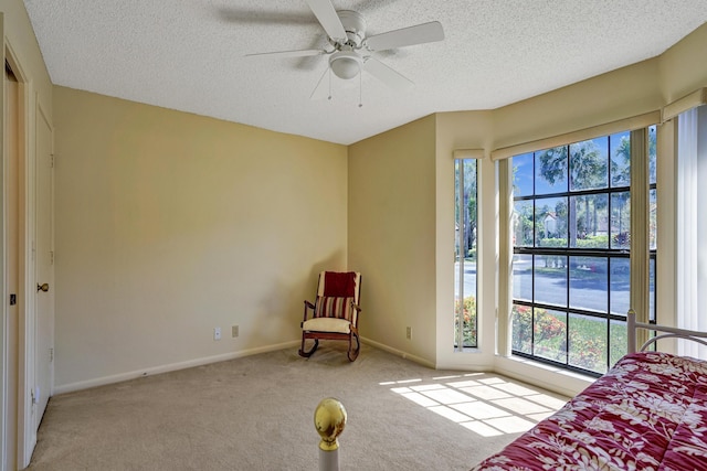 carpeted bedroom with baseboards, a textured ceiling, and a ceiling fan