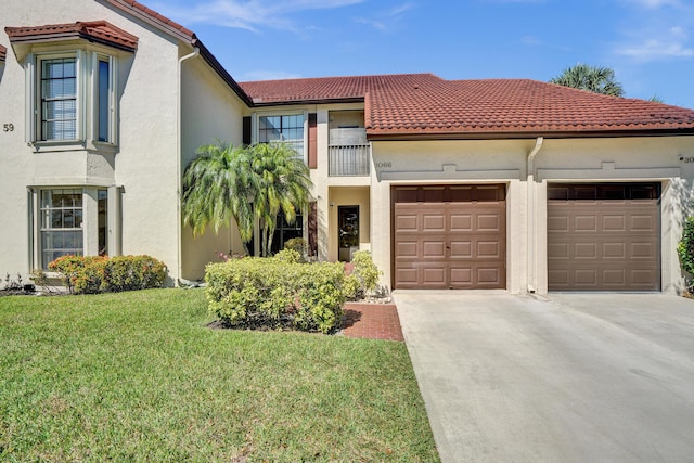 mediterranean / spanish-style house with a tiled roof, an attached garage, driveway, and stucco siding