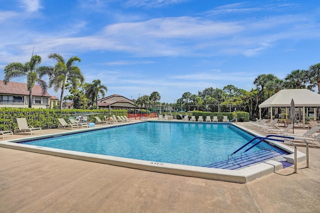 community pool with a patio and fence