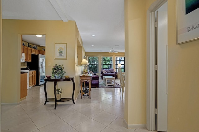 hall with light tile patterned flooring and baseboards