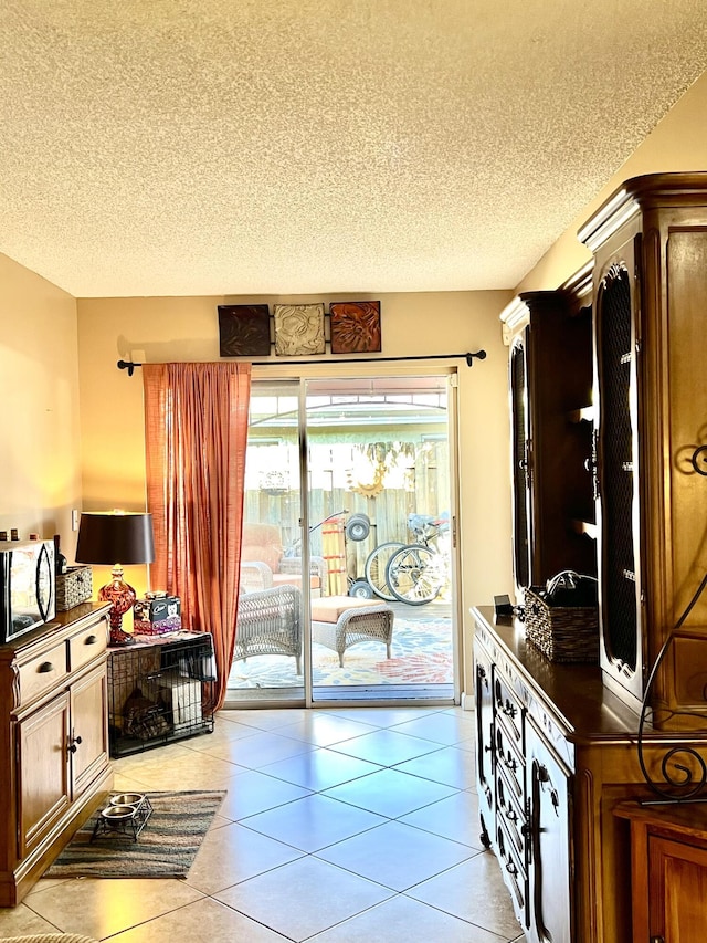 interior space featuring light tile patterned floors and a textured ceiling