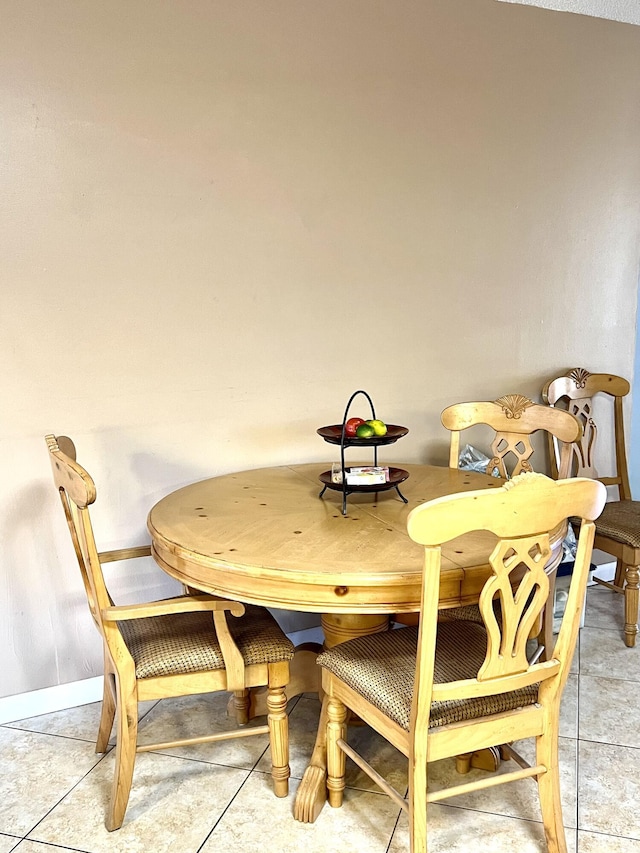 dining space featuring light tile patterned floors and baseboards