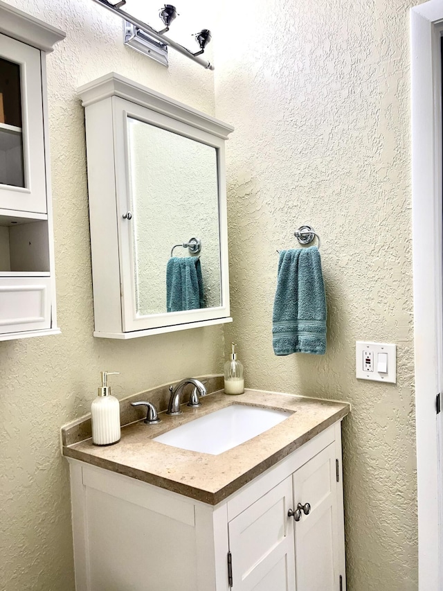 bathroom with vanity and a textured wall