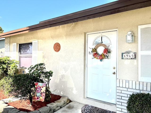 view of exterior entry featuring stucco siding