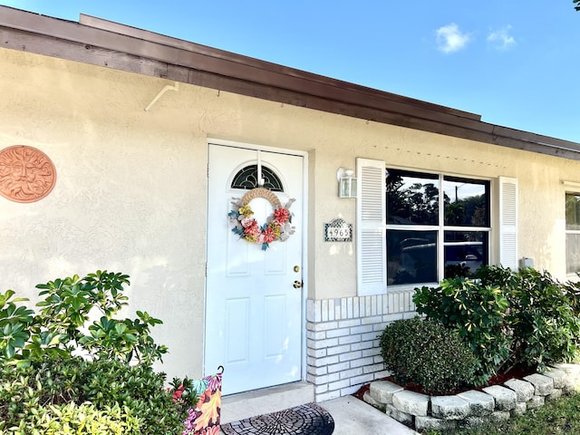 entrance to property featuring stucco siding