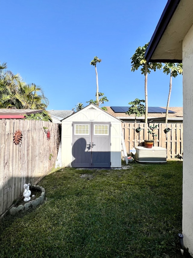 view of yard featuring an outbuilding, a storage shed, and a fenced backyard