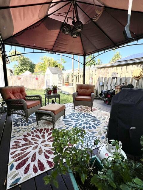 view of patio featuring an outbuilding, area for grilling, a shed, and fence