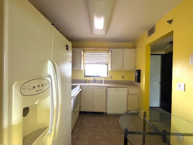 kitchen featuring white appliances, light tile patterned floors, a sink, light countertops, and white cabinetry