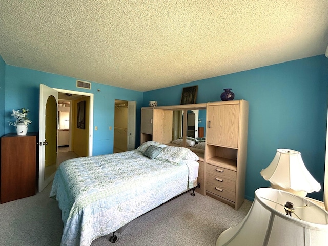 bedroom with visible vents, carpet, and a textured ceiling