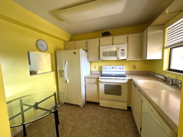 kitchen featuring tile patterned flooring, white appliances, light countertops, and a sink