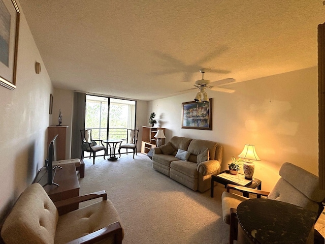 living area with a wall of windows, a ceiling fan, carpet flooring, and a textured ceiling