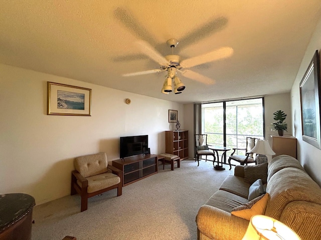 living area featuring carpet floors, a ceiling fan, floor to ceiling windows, and a textured ceiling