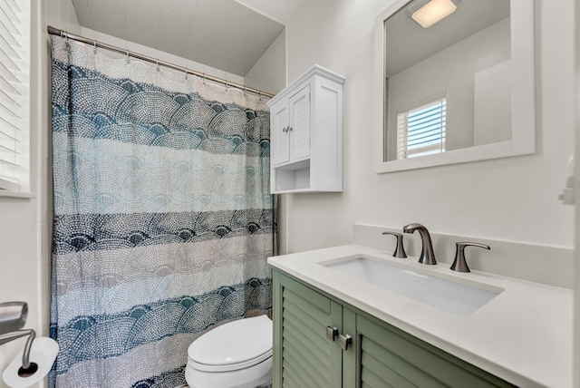 full bath featuring a shower with shower curtain, toilet, and vanity