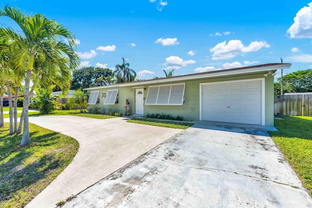 ranch-style house with concrete block siding, fence, concrete driveway, a front lawn, and a garage