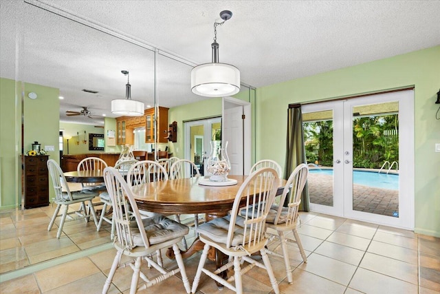 dining room featuring light tile patterned flooring, french doors, a textured ceiling, and ceiling fan