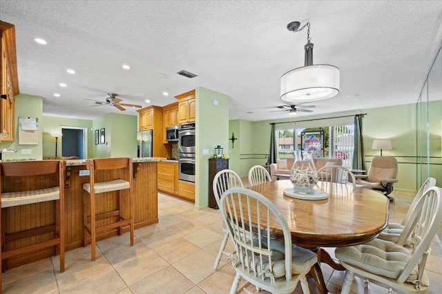 dining room with visible vents, a textured ceiling, ceiling fan, and light tile patterned flooring