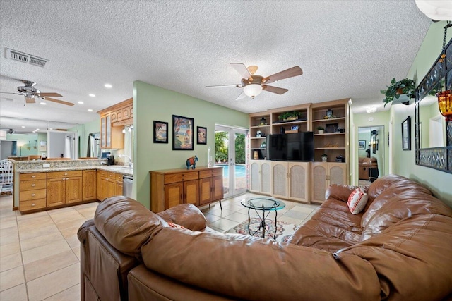 living area featuring light tile patterned floors, visible vents, french doors, and a ceiling fan