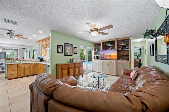 living area featuring light tile patterned floors, a ceiling fan, visible vents, and french doors