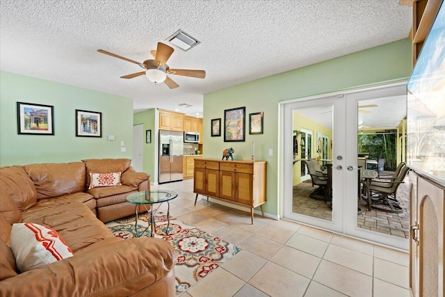 living room featuring visible vents, ceiling fan, light tile patterned floors, french doors, and a textured ceiling