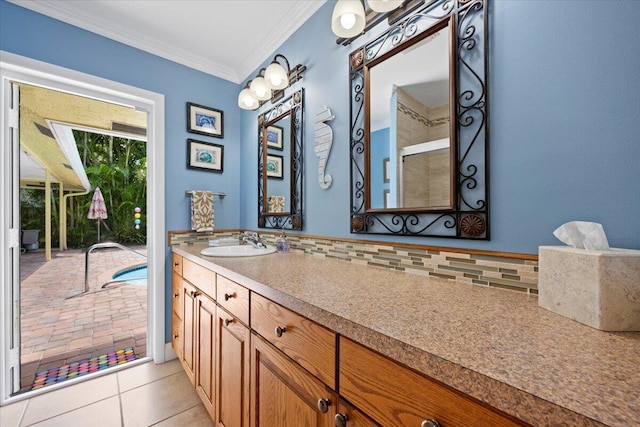 bathroom featuring tile patterned floors, backsplash, ornamental molding, and vanity