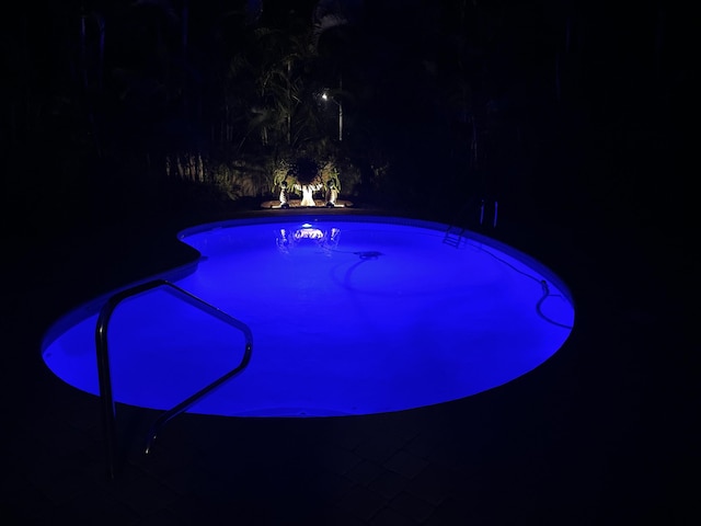 pool at night featuring an outdoor pool